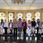 El alumnado y los familiares posan junto a la vicerrectora Rosario Hernández y la presidenta Rosa Morell, ambas en el centro.