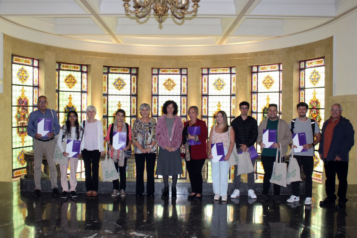 El alumnado y los familiares posan junto a la vicerrectora Rosario Hernández y la presidenta Rosa Morell, ambas en el centro.