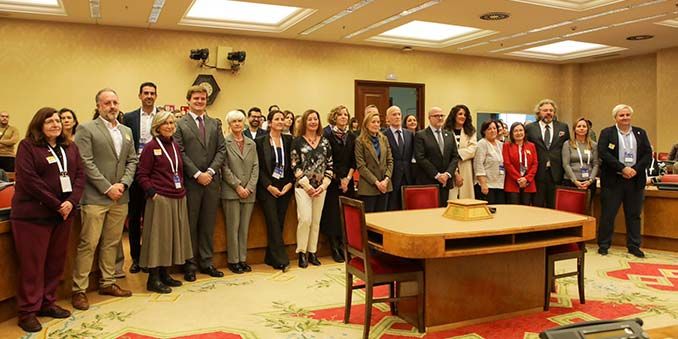 Foto de familia de los investigadores/as que han participado en los informes. En el centro de la imagen, con pantalón blanco, Francina Armengol, presidenta del Congreso. Carina González, con chaqueta roja, cuarta por la izquierda.