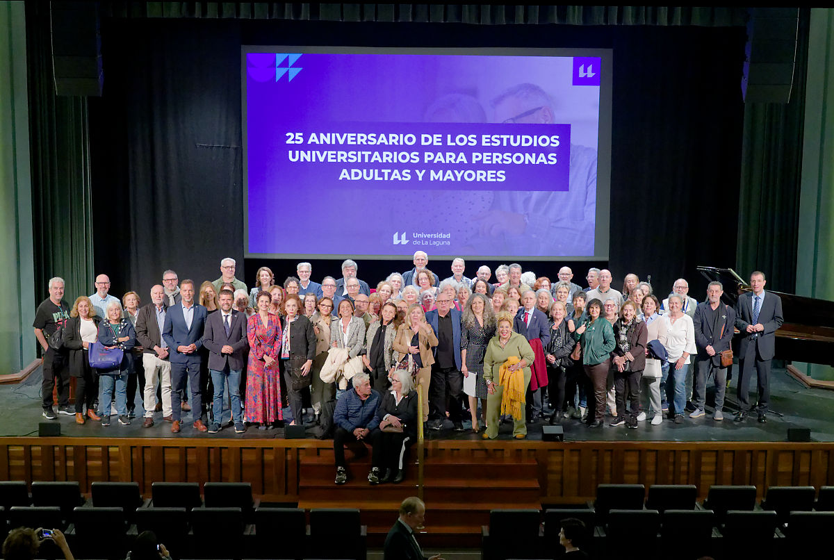 Foto de familia de las autoridades y participantes en el acto, con estudiantes actuales y pasados del programa.